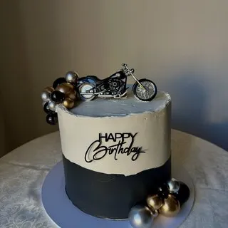The black and cream buttercream cake with silver baubles and a motorbike topper this comment was left on