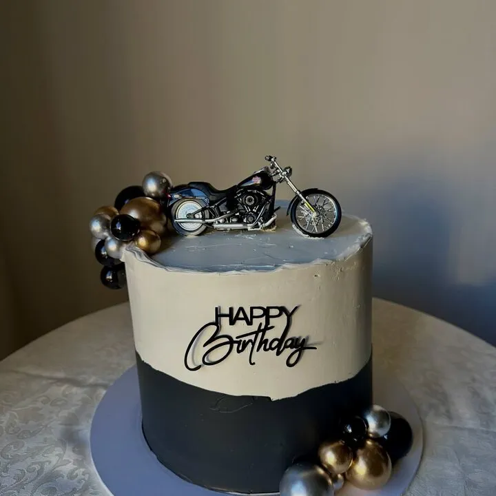 The black and cream buttercream cake with silver baubles and a motorbike topper this comment was left on