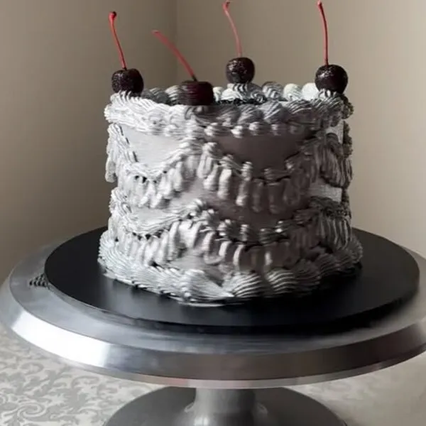 The silver buttercream cake with textured piping and glace cherries this comment was left on