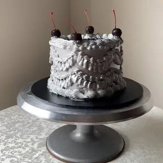 The silver buttercream cake with textured piping and glace cherries this comment was left on